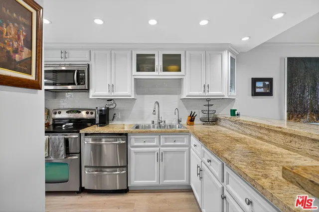 a kitchen with stainless steel appliances granite countertop a sink and a stove