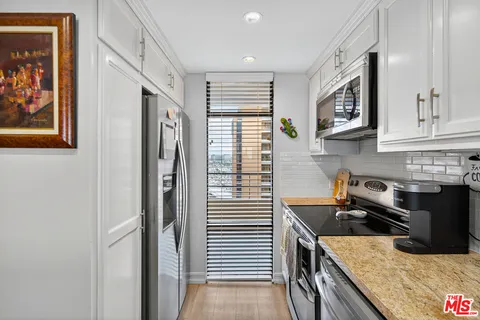 a kitchen with stainless steel appliances granite countertop a stove and a refrigerator