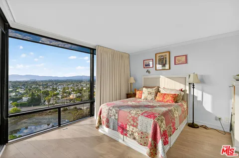 a bedroom with a bed and a large window