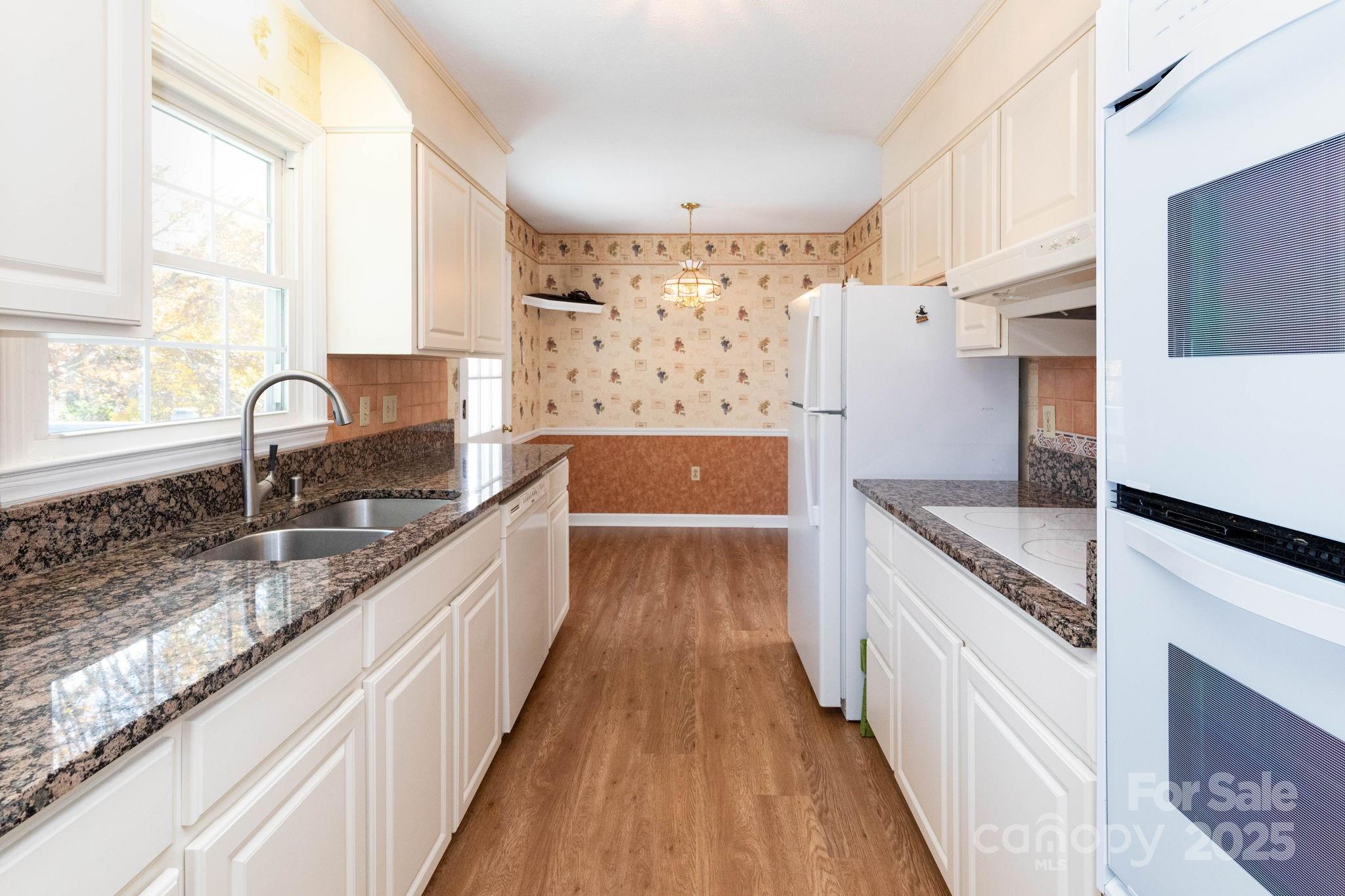 66 Gibson Road Asheville, NC 28804 - Photo 6 of 26 a large kitchen with kitchen island granite countertop a large window a sink and stainless steel appliances