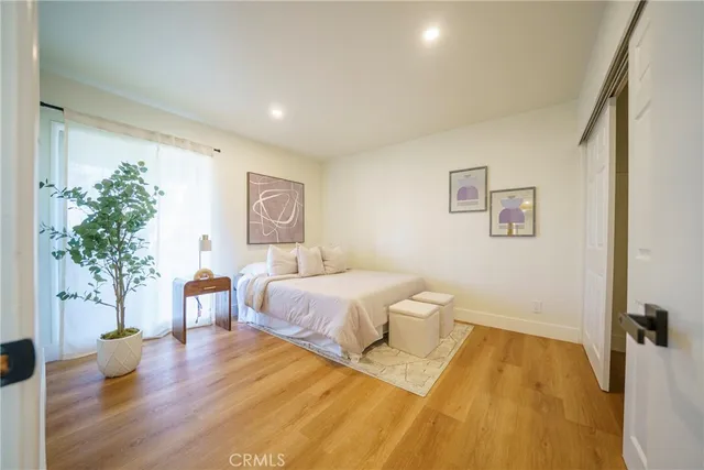 a spacious bedroom with a bed and a potted plant