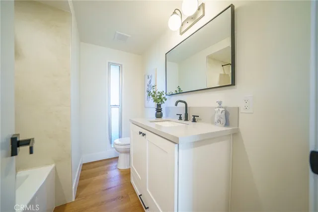 a bathroom with a sink a toilet and a mirror