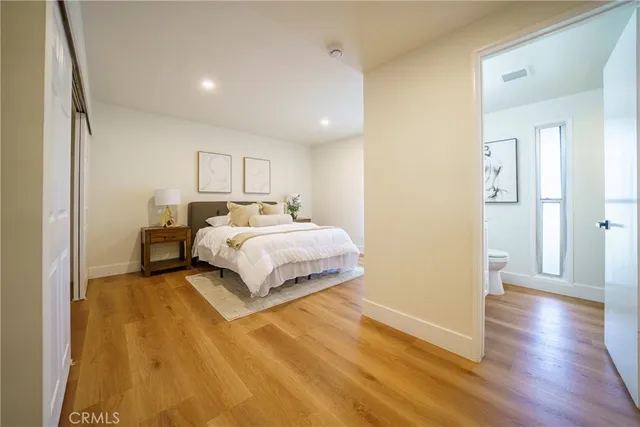 a bedroom with a bed and wooden floor