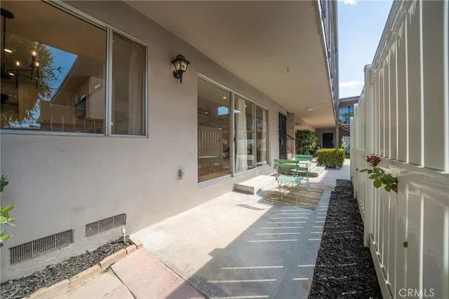 a view of a porch with chairs and potted plants