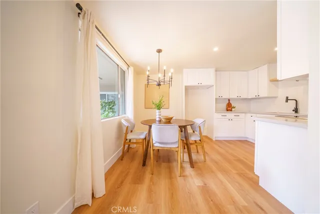 a dining room with stainless steel appliances furniture a window and kitchen view
