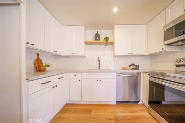 a kitchen with granite countertop cabinets stainless steel appliances and a sink