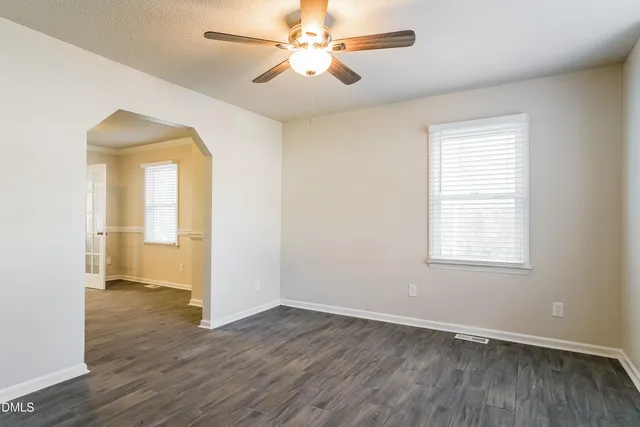 an empty room with wooden floor and a window