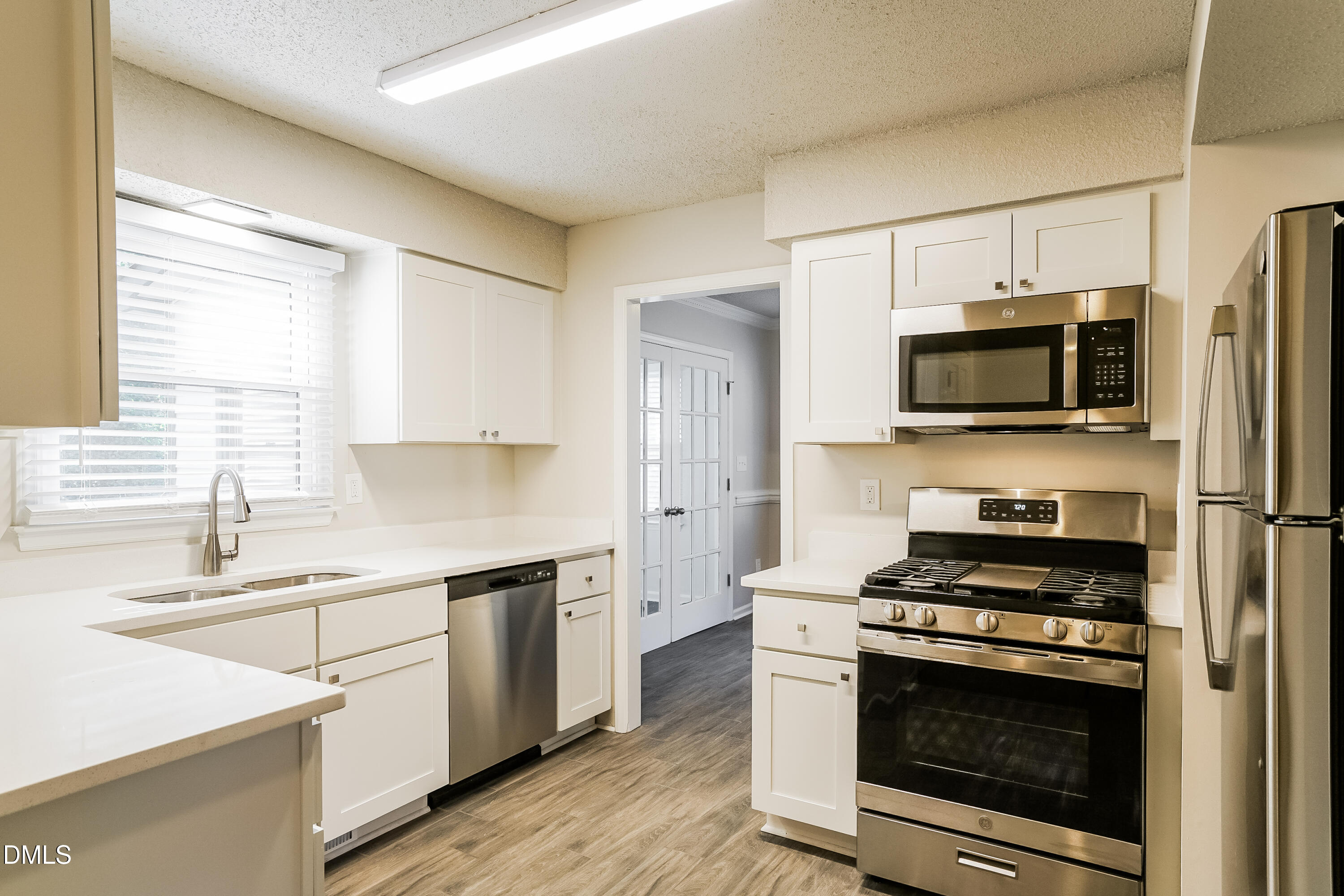 849 Rawls Drive Raleigh, NC 27610 - Photo 6 of 18 a kitchen with stainless steel appliances a stove a microwave a sink and cabinets