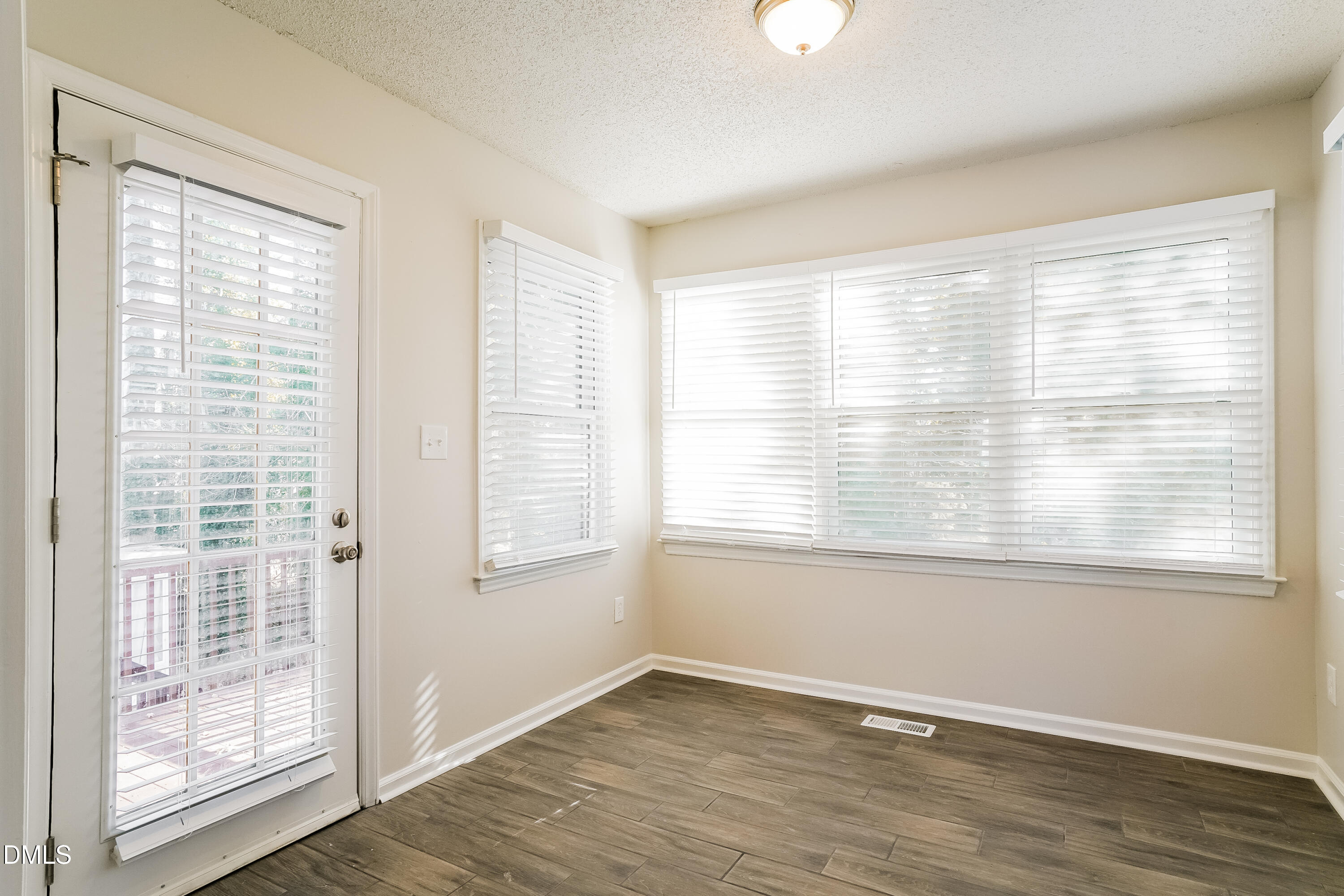 849 Rawls Drive Raleigh, NC 27610 - Photo 8 of 18 a view of an empty room with wooden floor and a window