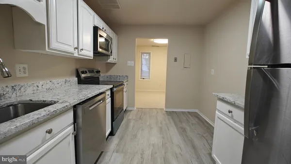 a kitchen with a sink a refrigerator a microwave and cabinets