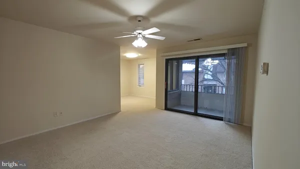 a view of a livingroom with a ceiling fan and window