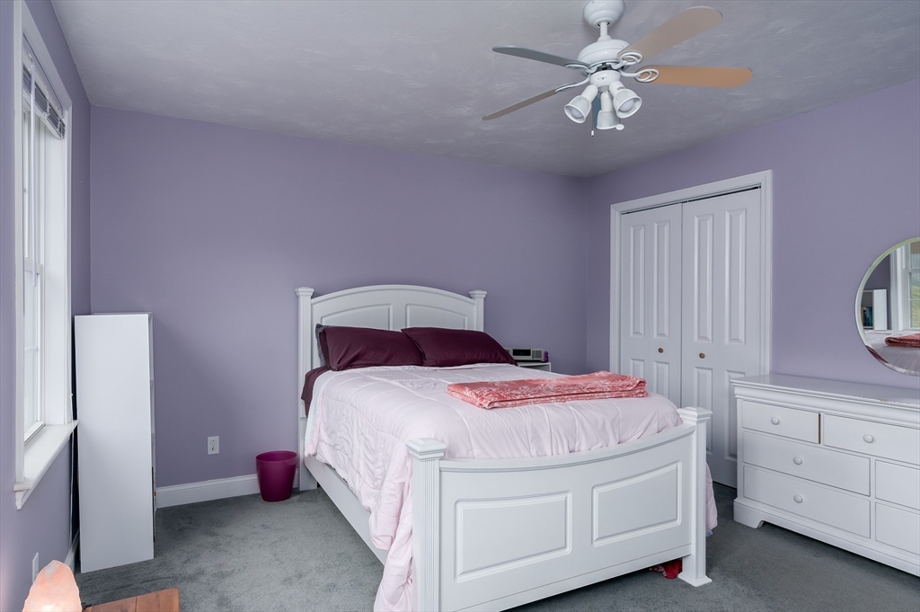 6 Nates Way Rutland, MA 01543 - Photo 25 of 31 a bedroom with a bed and a chandelier