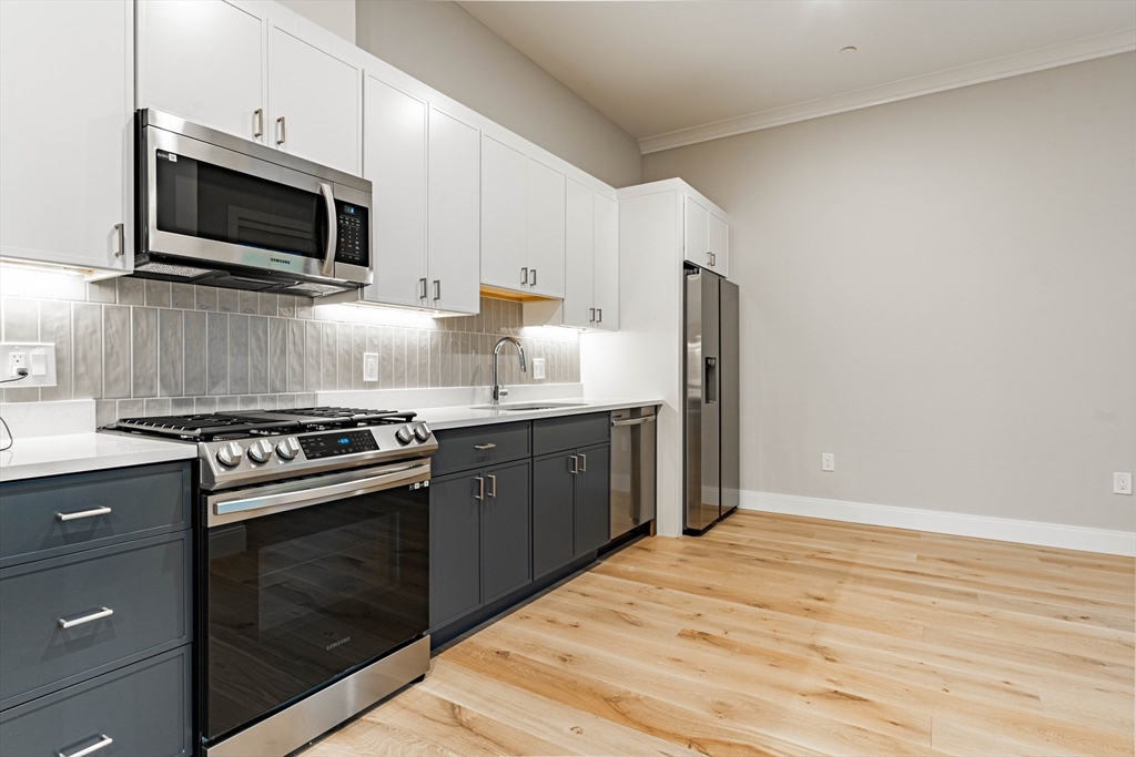a kitchen with stainless steel appliances a stove microwave and refrigerator