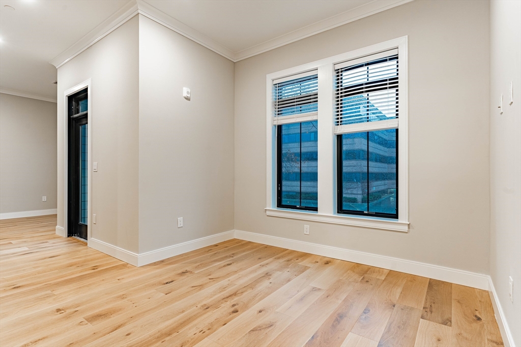 157 Everett Street, Unit 201 Boston, MA 02134 - Photo 3 of 8 an empty room with wooden floor and windows