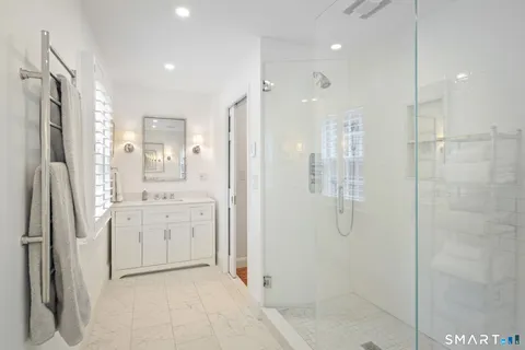 a bathroom with a granite countertop sink mirror and shower