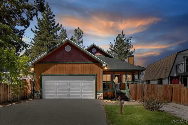 a view of barn with a small yard and large trees