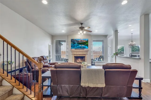 a living room with fireplace furniture and a large window