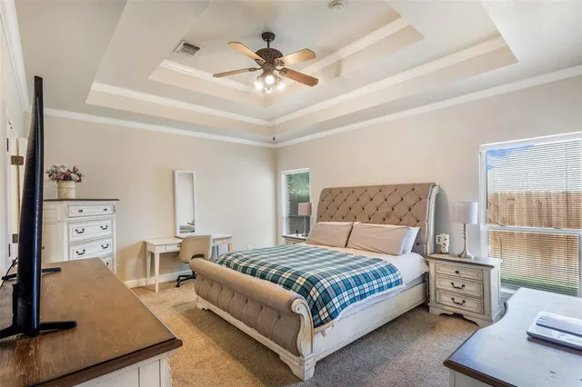 a bedroom with a large bed and a chandelier