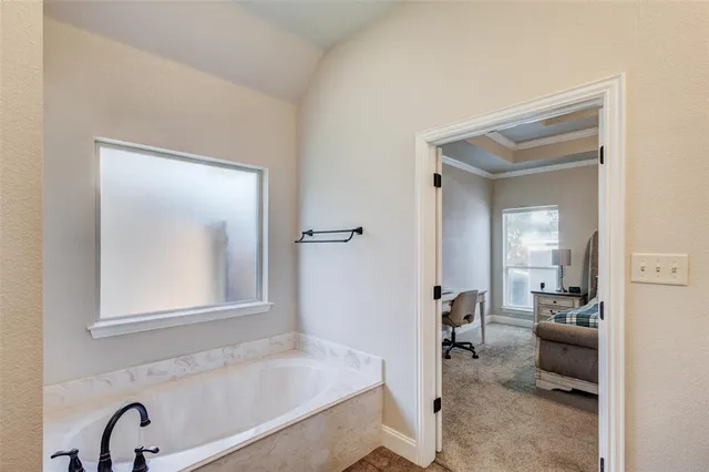 a en suite bathroom with a tub sink and mirror