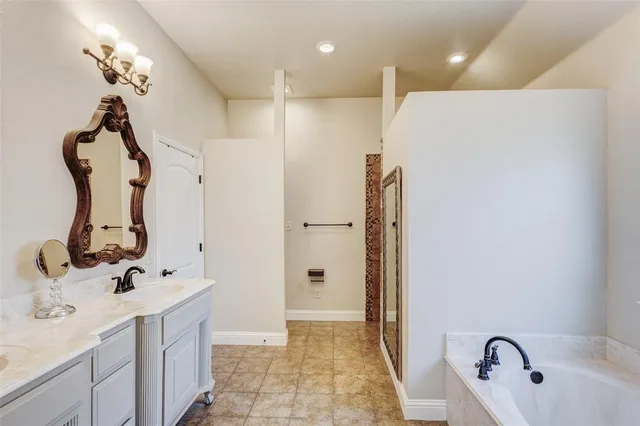 a bathroom with a tub sink and mirror