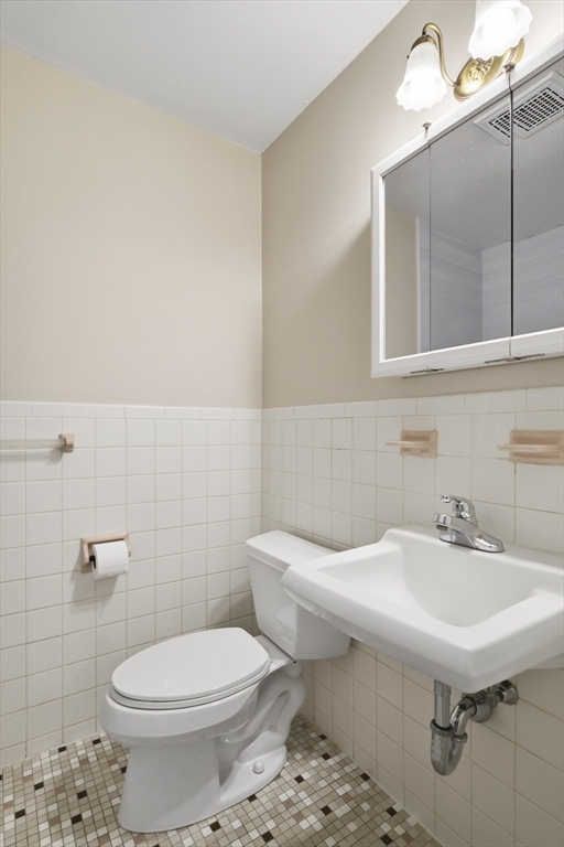 74 Barrett Street, Unit 308 Northampton, MA 01060 - Photo 12 of 22 a bathroom with a sink a toilet and mirror
