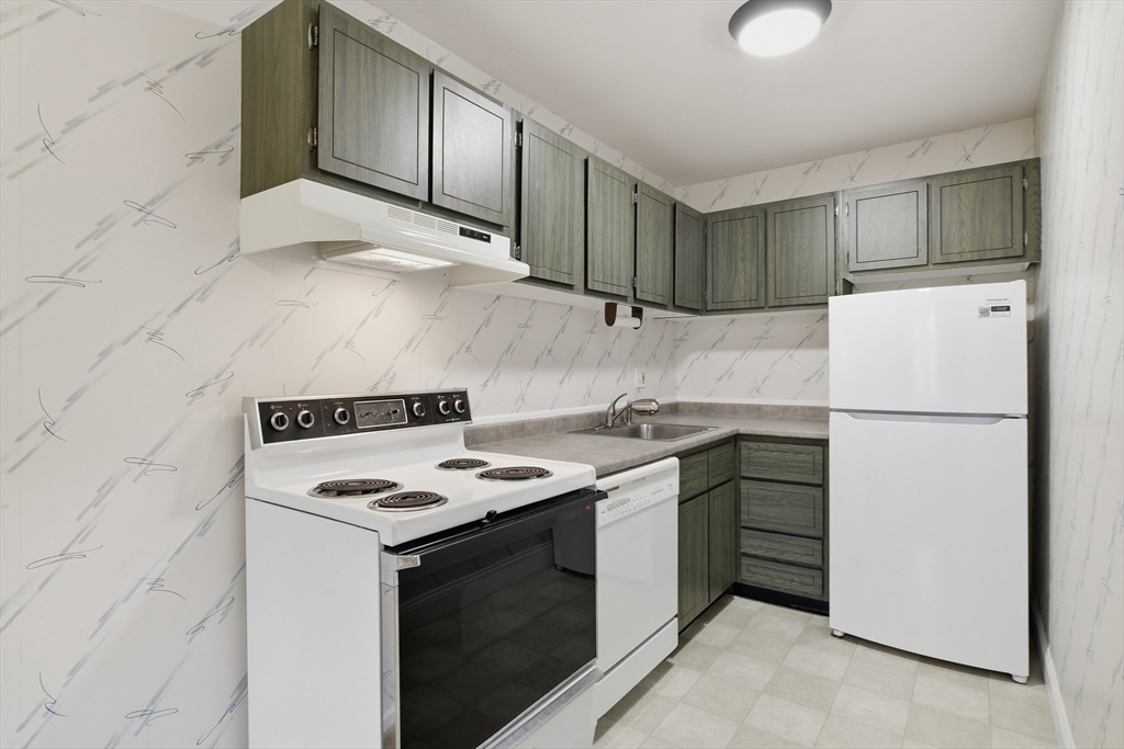 74 Barrett Street, Unit 308 Northampton, MA 01060 - Photo 6 of 22 a kitchen with stainless steel appliances a stove a refrigerator and a cabinets