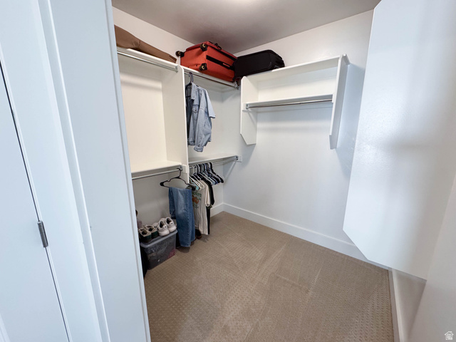 1486 West 2055th Street South Logan, UT 84339 - Photo 20 of 45 Walk-in closet featuring built-in white shelving, multiple hanging rods, and carpet flooring