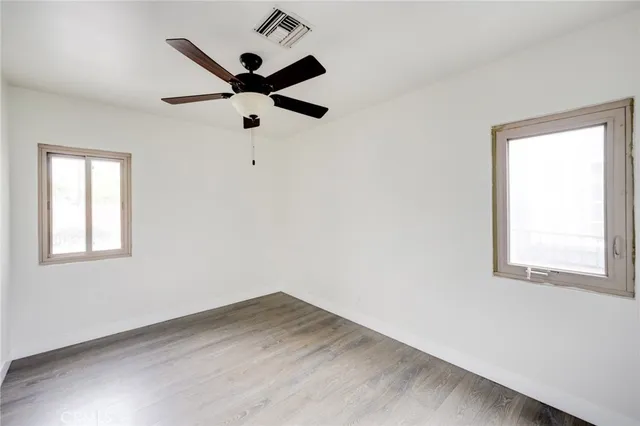 a view of a room with wooden floor and ceiling fan