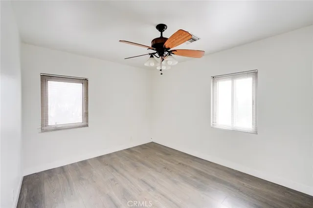 a view of a room with wooden floor and a ceiling fan