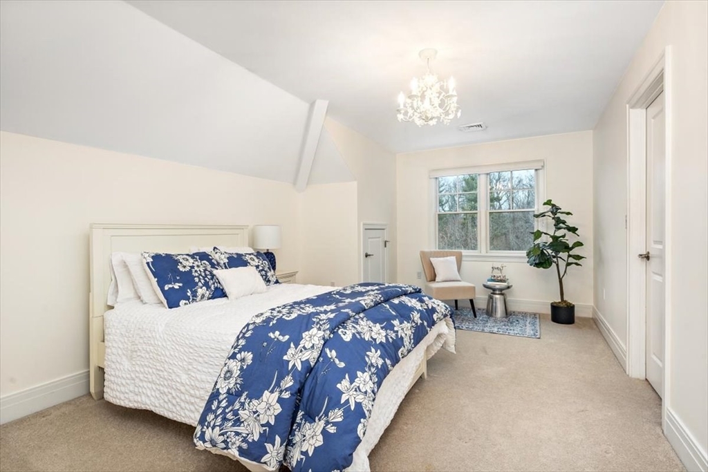 22 Raynor Drive, Unit 22 Hingham, MA 02043 - Photo 24 of 41 a bedroom with a large bed and a chandelier fan