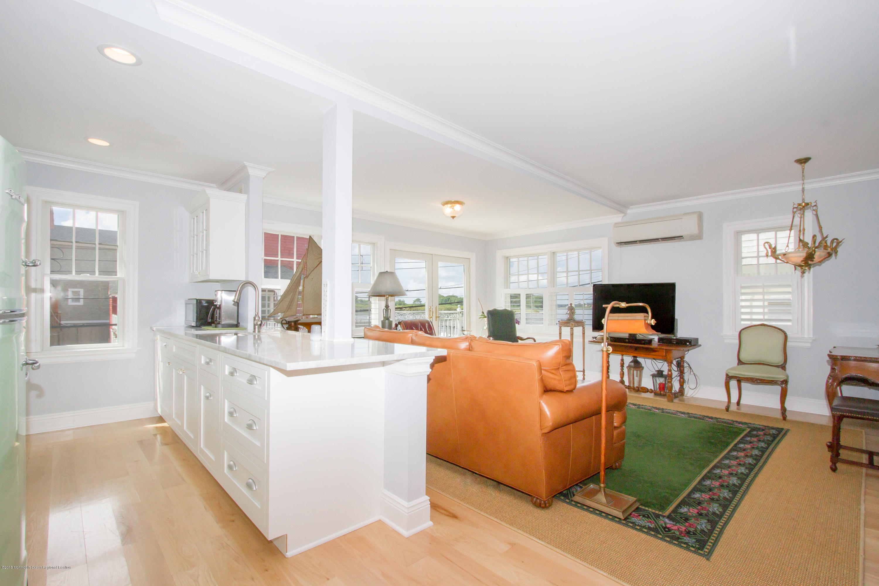 27 Center Street Sea Bright, NJ 07760 - Photo 12 of 51 a large living room with stainless steel appliances granite countertop couches a fireplace a flat screen tv and a dresser