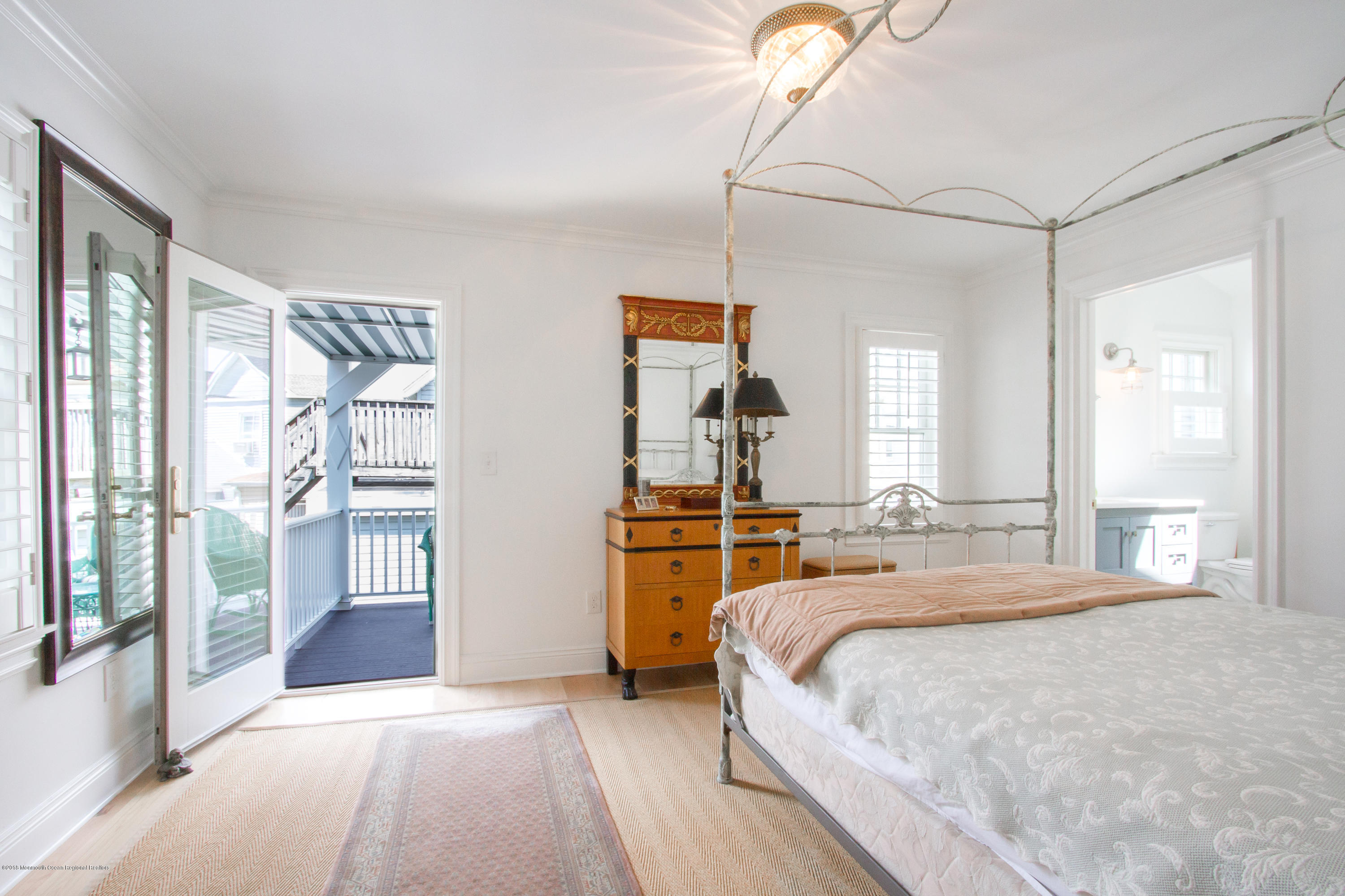 27 Center Street Sea Bright, NJ 07760 - Photo 18 of 51 a bedroom with a large bed and a chandelier