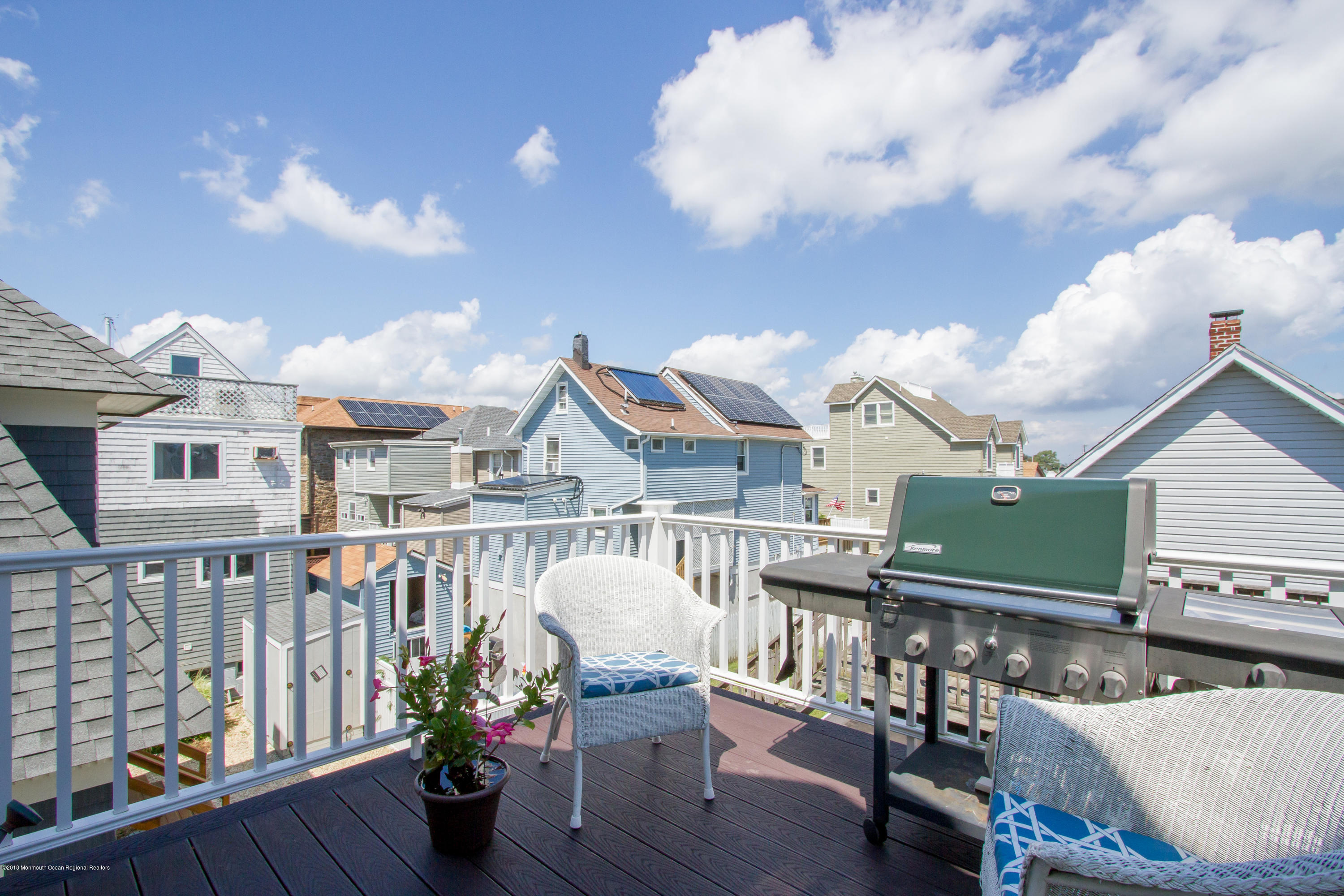 27 Center Street Sea Bright, NJ 07760 - Photo 34 of 51 a roof deck with table and chairs a barbeque with wooden floor and fence