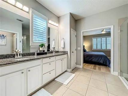 a spacious en suite bathroom with a double vanity sink and a mirror