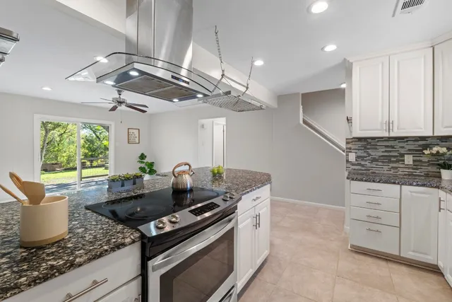 a kitchen with granite countertop a stove a sink and a cabinets