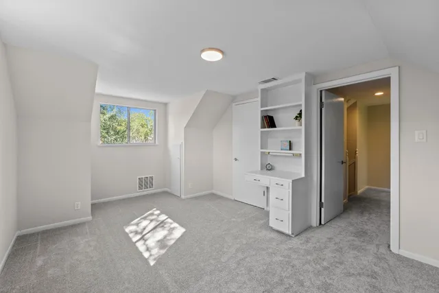 an empty room with windows and cabinet