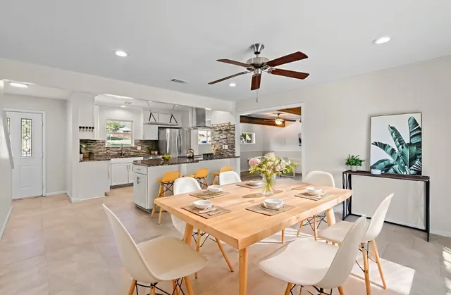 a living room with stainless steel appliances kitchen island furniture and a dining table
