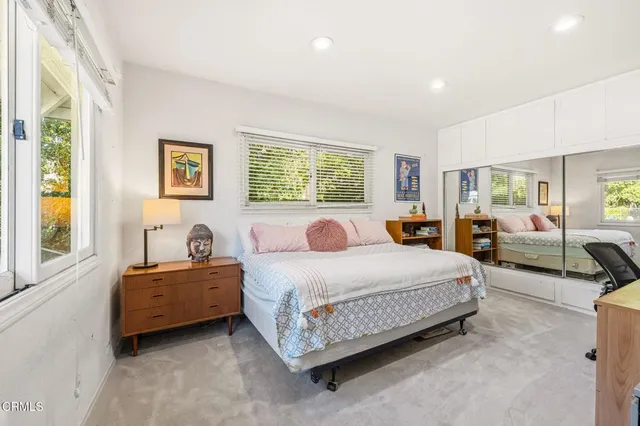 a bedroom with a bed and dresser with window