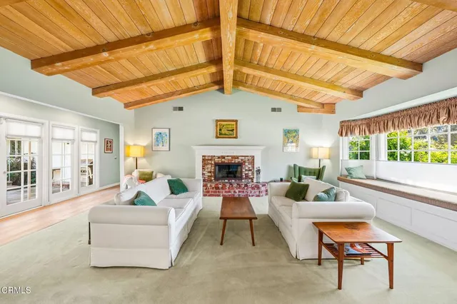 a living room with furniture a fireplace and a large window