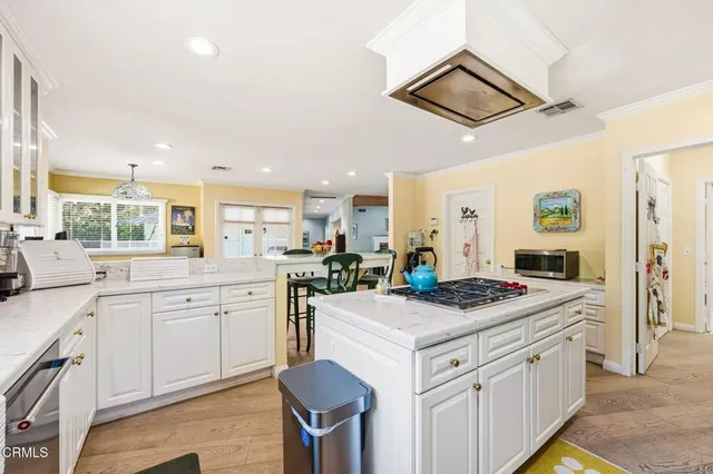 a kitchen that has a sink a stove and chairs