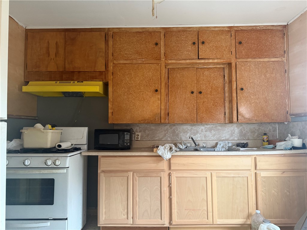 708 Louis Street Alice, TX 78332 - Photo 5 of 7 a kitchen with stainless steel appliances granite countertop a sink stove and cabinets