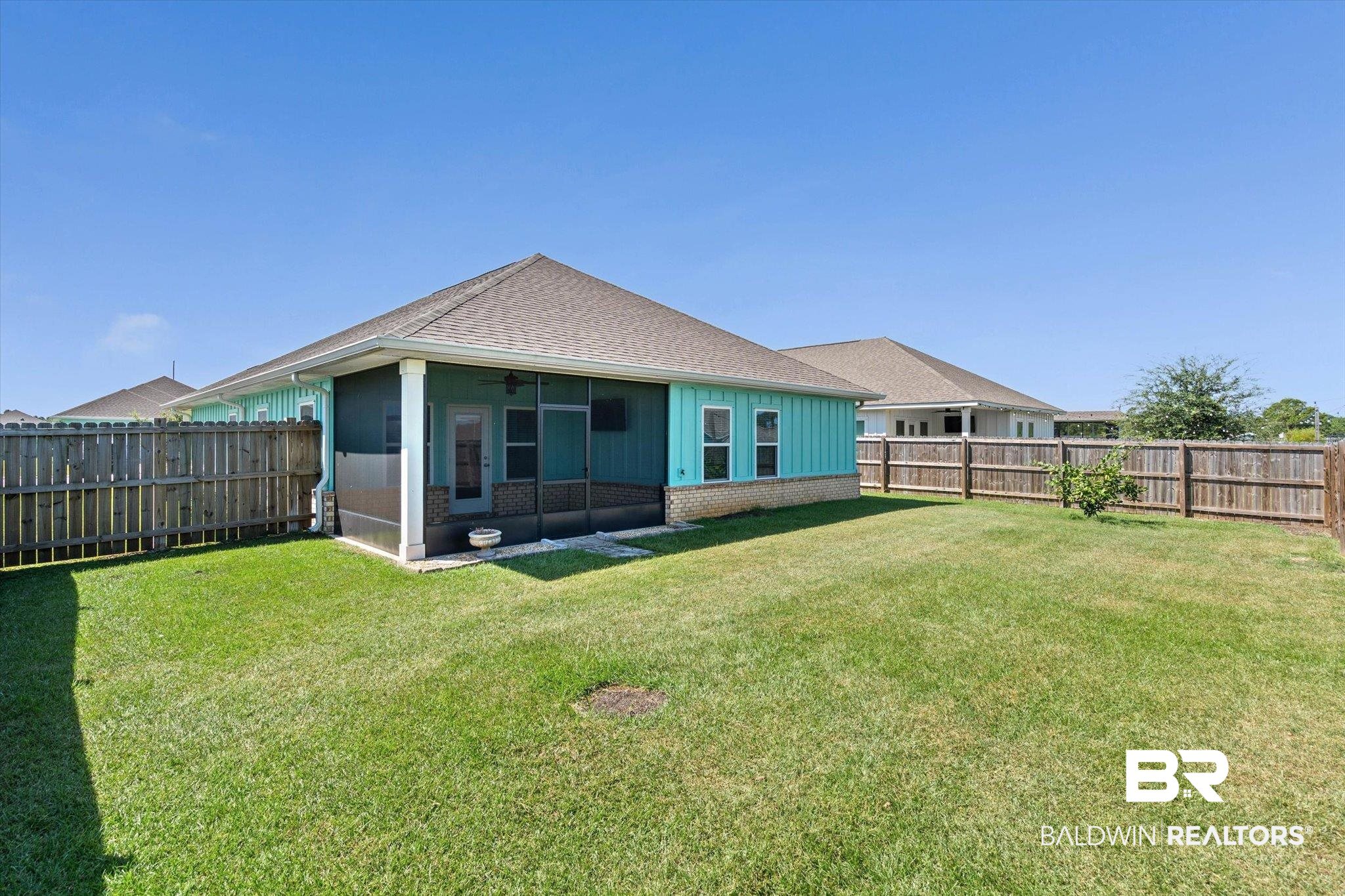 22976 Lieutenant Avenue Foley, AL 36535 - Photo 19 of 30 Back of house with a sunroom, a fenced backyard, a shingled roof, and ceiling fan