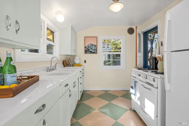 a kitchen with stainless steel appliances granite countertop a sink and a stove next to a window