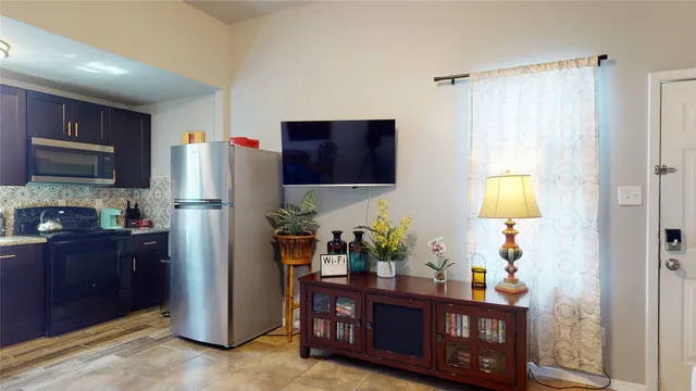a kitchen with stainless steel appliances granite countertop a refrigerator and a wooden cabinets