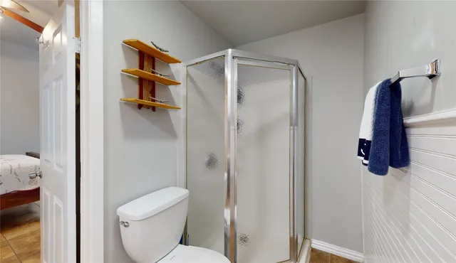 a bathroom with a toilet and a shower