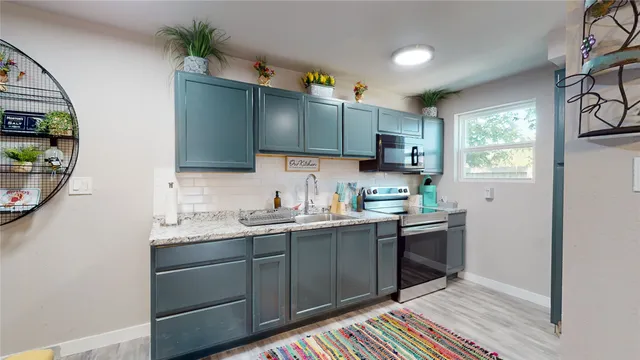 a kitchen with stainless steel appliances granite countertop a sink stove and cabinets
