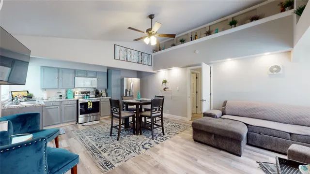 a living room with furniture a dining table and a chandelier