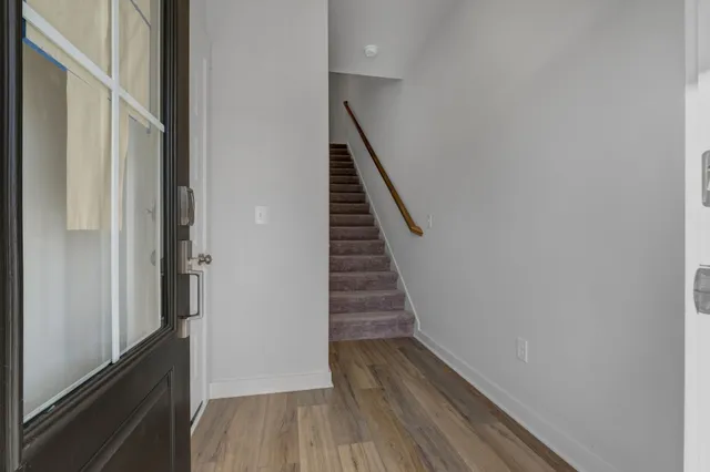a kitchen with white cabinets and wooden floor