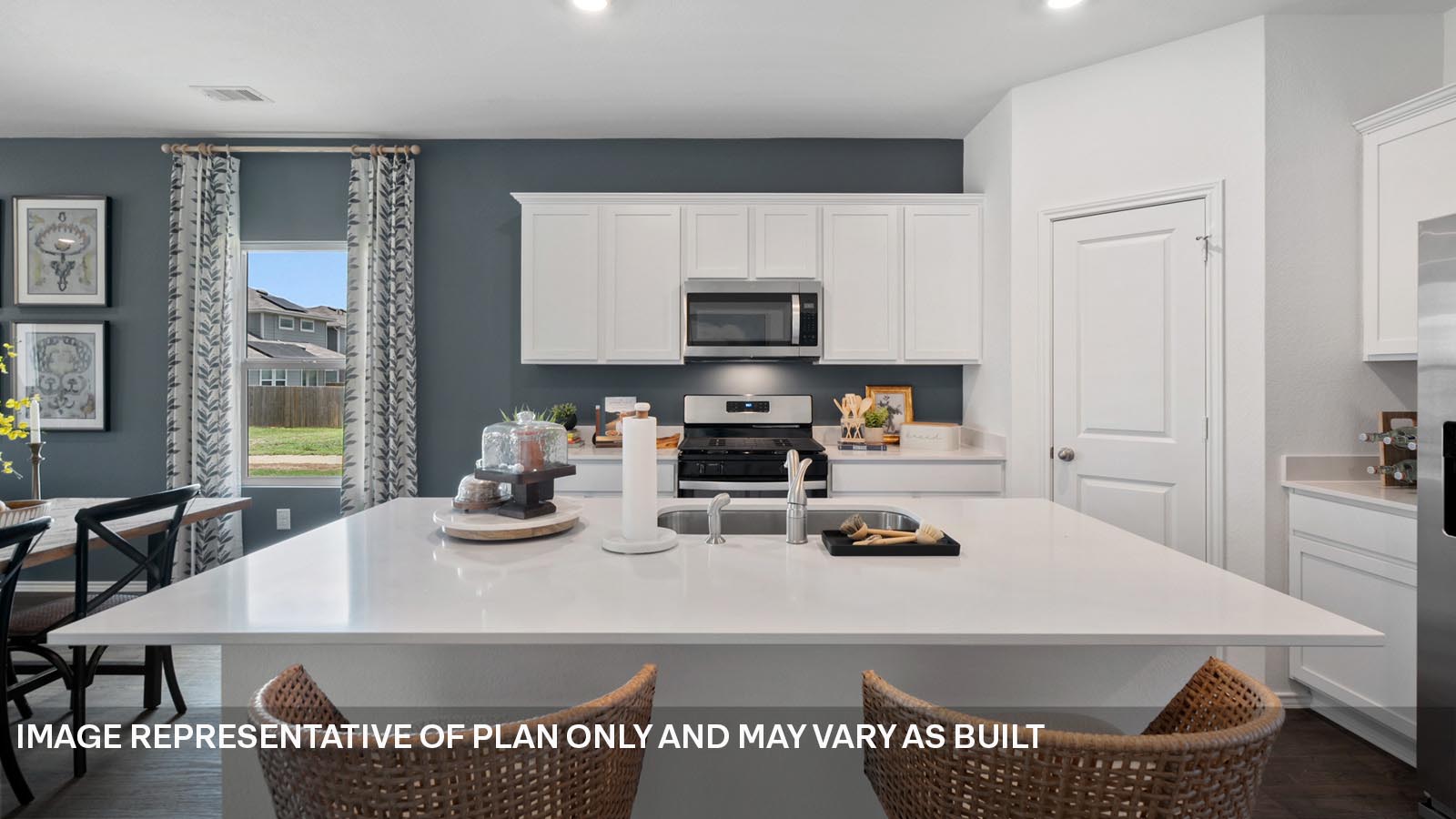 174 Balmorhea Street Kyle, TX 78640 - Photo 5 of 27 a kitchen with a sink a stove and chairs