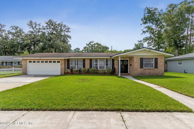 a view of a house with a yard and a tree